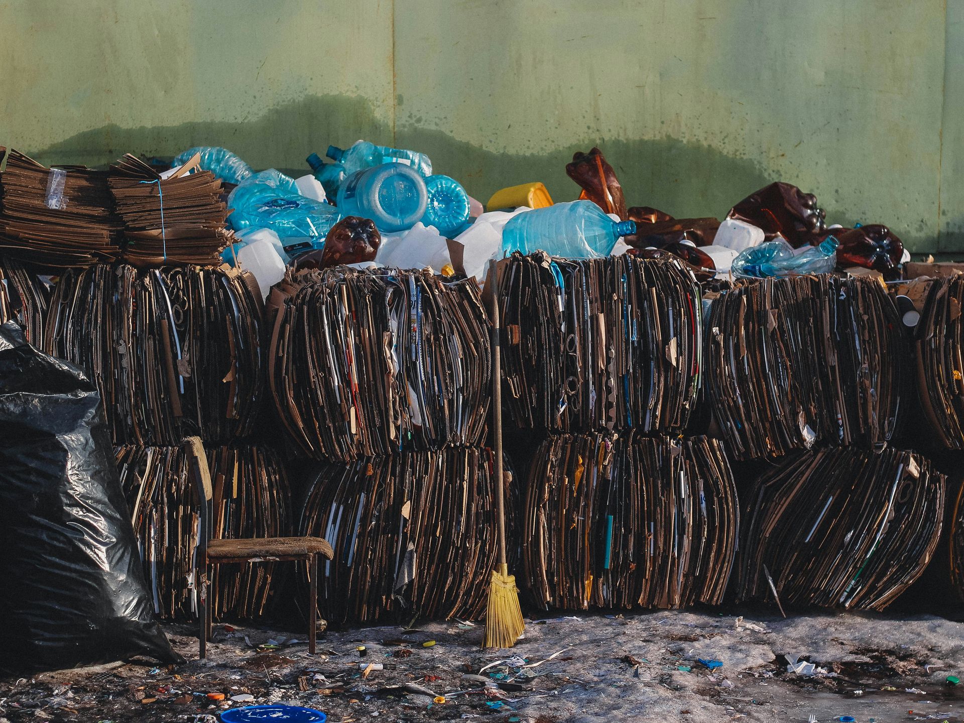 a pile of trash sitting next to a green wall